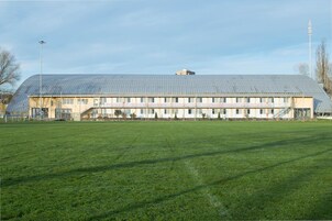 A large, single-story building with a flat roof and a long, rectangular structure.