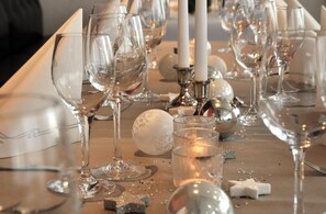 A table with empty wine glasses, candles, and scattered debris.