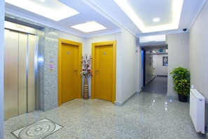 Stunning lobby area with elevators, granite wall, and decorative touches.