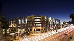 A multi-story hotel with a modern design, featuring a curved facade and illuminated windows. - VIP Hollywood LA 5BD Pool Walk of Fame (Los Angeles)
