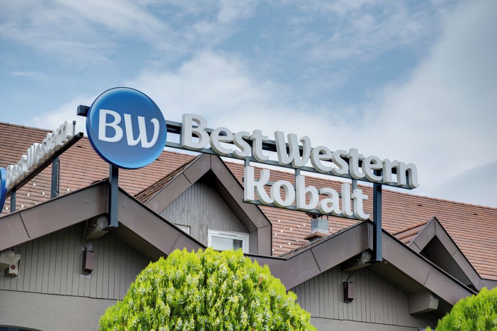 Une enseigne d’hôtel portant le nom « BW Best Western Kobalt » et un logo circulaire bleu.