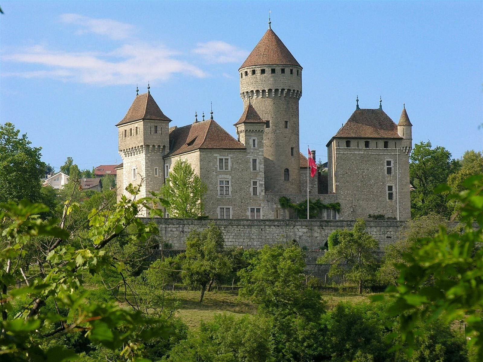 A historic castle with multiple towers and a flagpole.