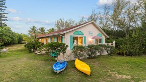 Una casa con un porche, dos kayaks y una estatua.