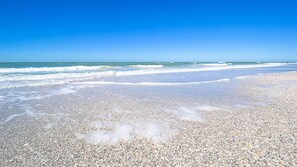 A beach with pebbly shore and waves approaching.