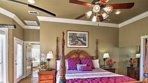 A spacious bedroom with a four-poster bed, a ceiling fan, and a painting on the wall. - A luxury hunting lodge  (Merkel)