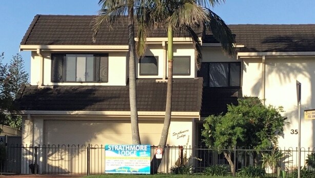 A two-story building with a sign for Strathmore Lodge. - "Strathmore Lodge" - UNIT 1A LOWER LEVEL. (Port Macquarie)