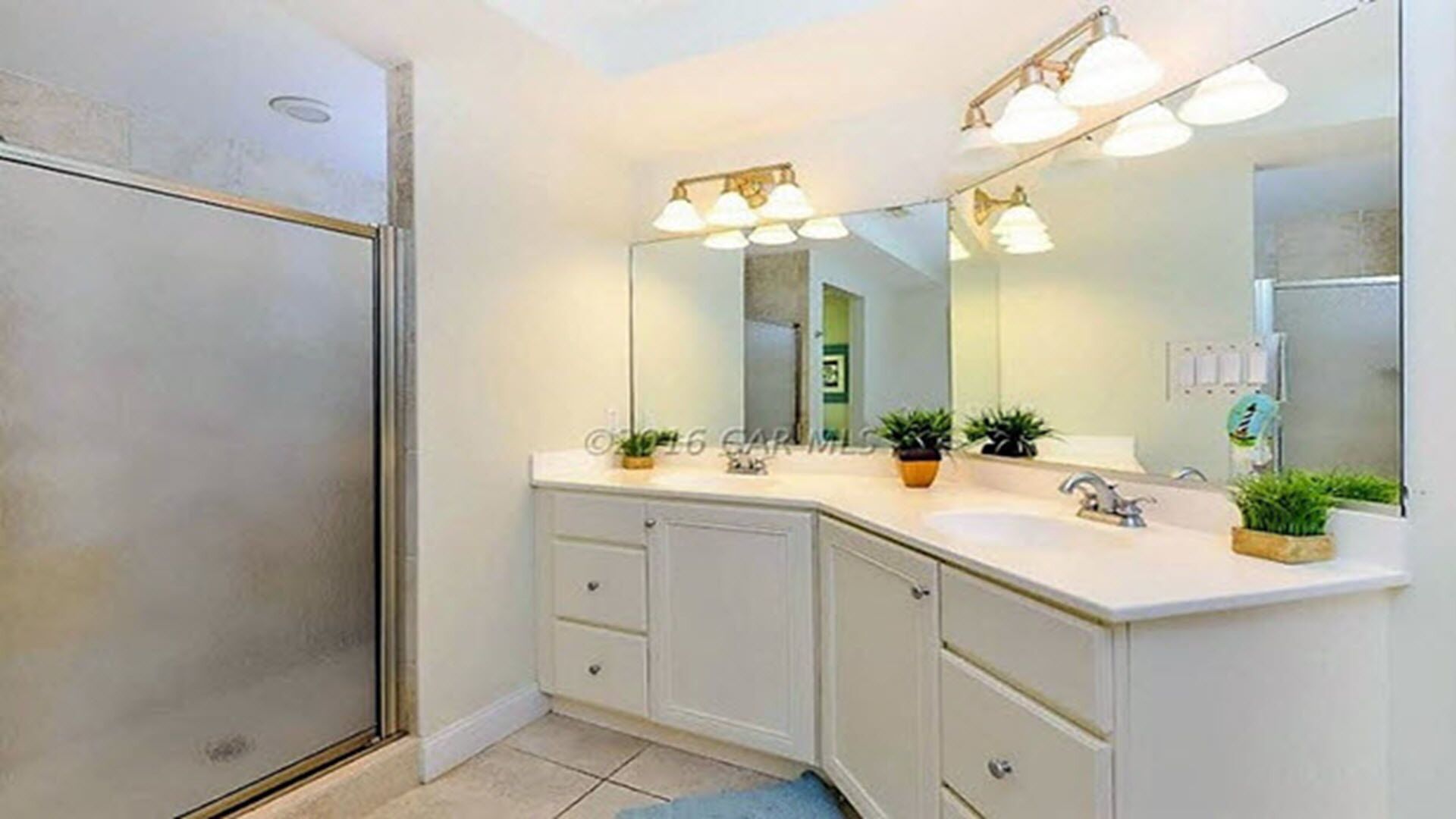 Une salle de bain avec une douche, un lavabo et un miroir.