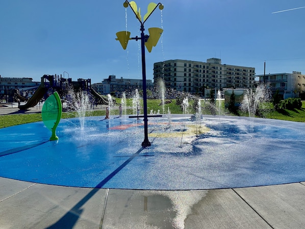 Un élément décoratif aquatique composé de plusieurs fontaines, situé dans un parc.