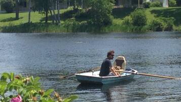 A small boat on a calm lake with a person and a dog on board.