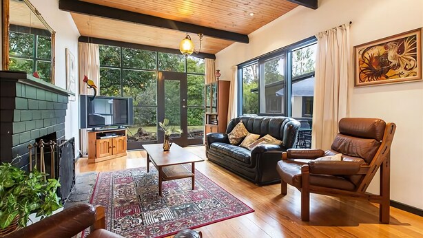 A cozy living room with a fireplace, leather sofa, and a television. - Tranquil Oasis - Pet friendly (BALNARRING BEACH)