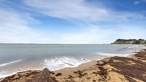 A beach with clear skies, calm waters, and rocky shorelines. - Tranquil Oasis - Pet friendly (BALNARRING BEACH)