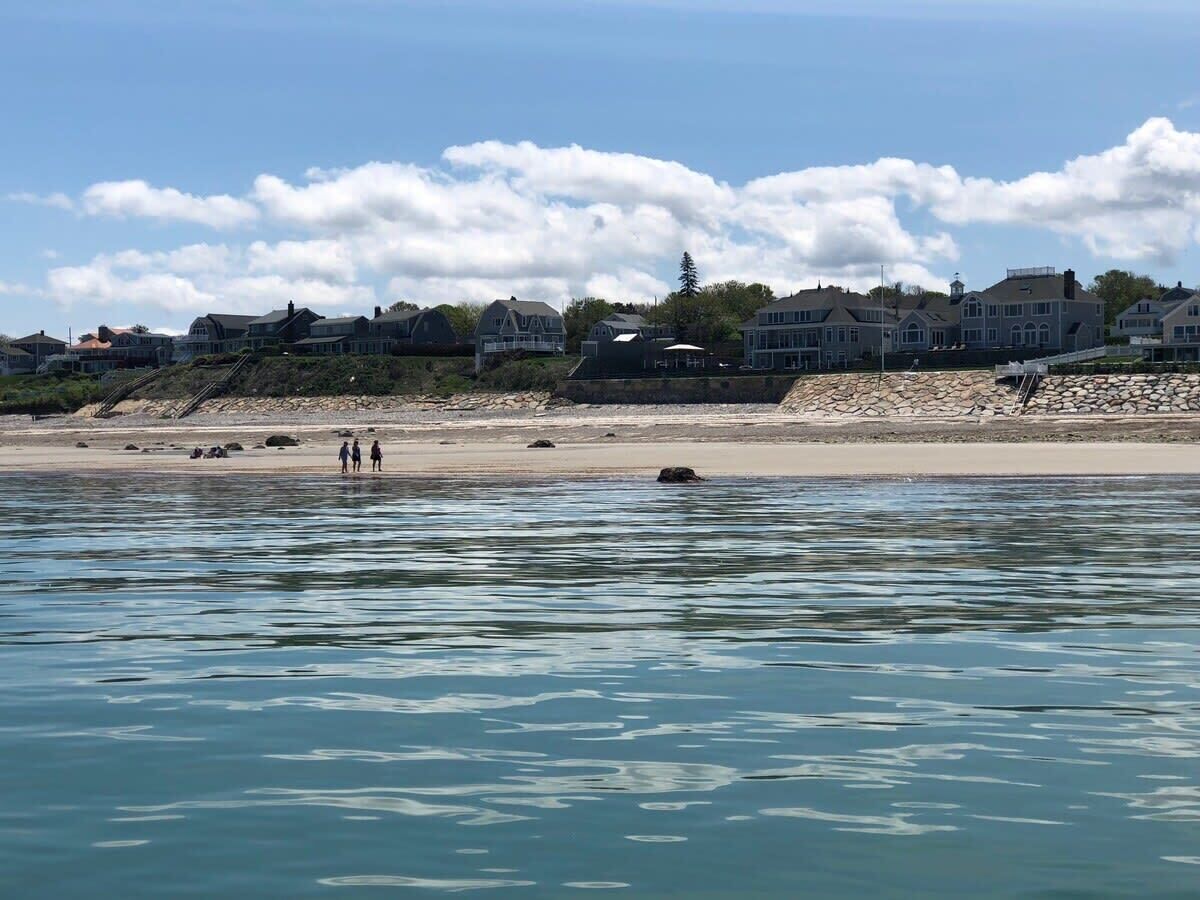 A waterfront property with a sandy beach and a row of houses.