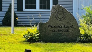 Un marqueur en pierre portant l’inscription « Priscilla Beach Clubhouse » et une plaque indiquant l’année 1951.
