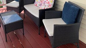 A porch with wicker furniture, including two chairs and a small table. - Brigantine~2blks to beach~2bdr~1bth~front porch~bck deck~fencedyard ~allow dogs (Brigantine)