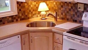 A kitchen with wooden cabinets, a stainless steel sink, a microwave, and a stove. - Brigantine~2blks to beach~2bdr~1bth~front porch~bck deck~fencedyard ~allow dogs (Brigantine)