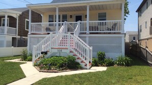 A two-story house with a front porch, a staircase, and a number '108' on the front steps. - Brigantine~2blks to beach~2bdr~1bth~front porch~bck deck~fencedyard ~allow dogs (Brigantine)