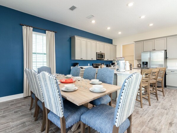 A modern kitchen with white cabinets, a microwave, and a refrigerator.