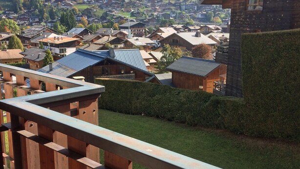 A wooden balcony with a view of a village and mountains. - Modern, luxury studio in Morzine,1st floor, sleeps 4, centrally located (Morzine)