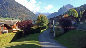 A rural road leading to a village with traditional wooden houses, surrounded by mountains and autumn foliage. - Modern, luxury studio in Morzine,1st floor, sleeps 4, centrally located (Morzine)