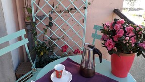 A small outdoor table with a purple tablecloth, two cups, a coffee pot, and a potted plant with pink flowers. - La Casa di Azzurra for Cinque Terre<br>Cod.Citra 011015-LT-0171 (La Spezia)