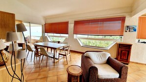A dining area with a table and chairs, a wicker sofa, and a small round table. - house / villa - Solenzara (Sari-Solenzara)