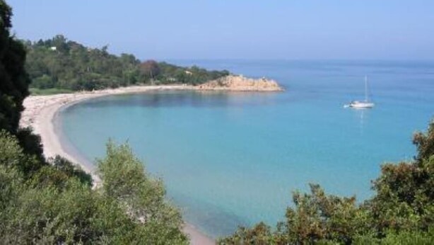 A coastal landscape with a sandy beach, a small island, and a sailboat in the distance. - house / villa - Solenzara (Sari-Solenzara)