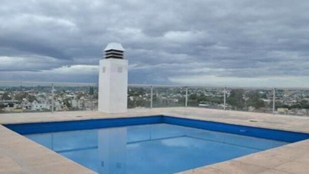 A rooftop swimming pool with a view of a cityscape. - Güemes Flat 45Z (Córdoba)