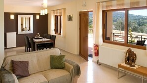 Un salon comprenant un canapé, une table à manger avec des chaises, un banc et une vue sur l’extérieur.
