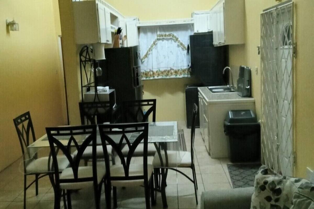 A compact kitchen with a dining area, a small refrigerator, and a microwave.