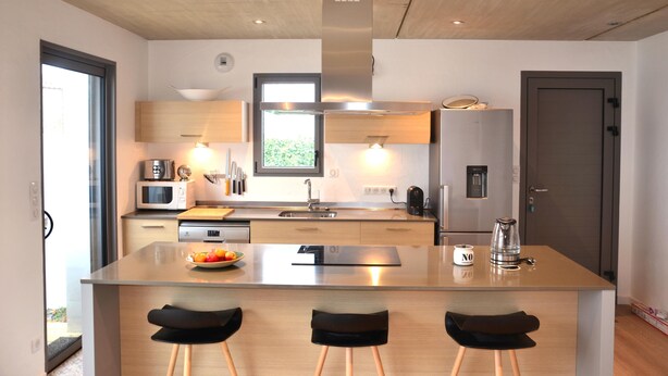 A modern kitchen with a central island, stainless steel appliances, and wooden cabinetry. - CHARMING HOME BETWEEN DOWNTOWN AND THE BEACHES (Noirmoutier-en-l'Île)