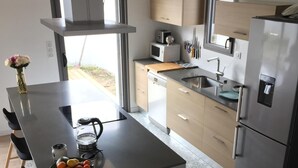 A modern kitchen with a central island, stainless steel appliances, and a view to the outside. - CHARMING HOME BETWEEN DOWNTOWN AND THE BEACHES (Noirmoutier-en-l'Île)