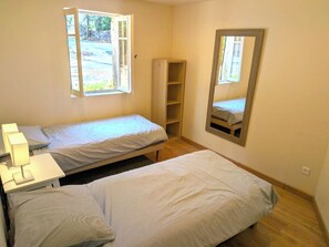 A small, single-room accommodation with two beds, a nightstand, a mirror, and a window. - Farmhouse in Uzès: 7 bedrooms, 17 beds, 12X8m pool, 4 bathr., 5000m²garden, WIFI (Uzès)