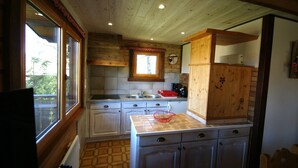 A kitchen with wooden cabinets, a window, and a tiled backsplash.
