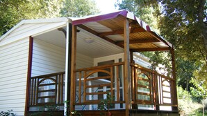 A mobile home with a wooden deck and a covered porch.