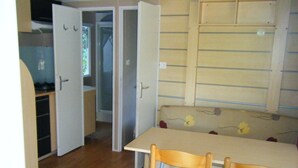 A compact kitchen with a dining area, wooden chairs, and a bench.