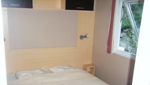 A single bed with a wooden headboard and a small bedside table.