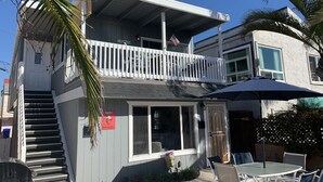 A two-story building with a balcony, a sign indicating 'Angela's', and outdoor seating. - Ocean View Beach House On Jersey Ct just steps to the beach (San Diego)
