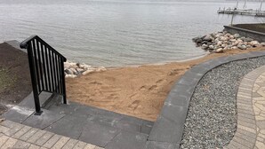 A lakeside walkway with a bench, a sandy area, and a dock. - 6BR Alexandria Lakefront, FREE Pontoon, Designed for Groups (Alexandria)