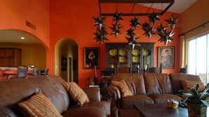 A spacious living room with leather sofas, a wooden coffee table, and a decorative star chandelier. - Beachfront  Luxury Penthouse at Paraiso Del Mar (La Paz)