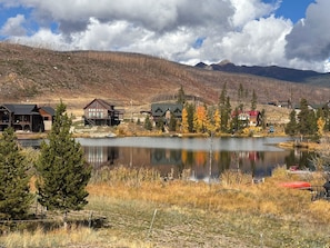 A lakeside property with cabins, a dock, and a mountain backdrop.
