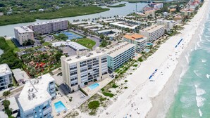 Un hotel costero con varias edificaciones, una playa y un río.