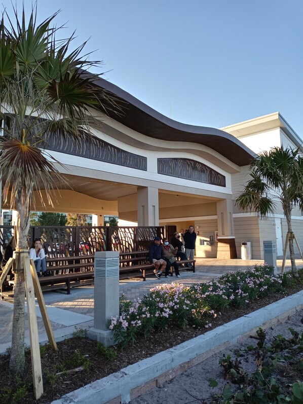 A modern building with a curved roof and a covered outdoor seating area.