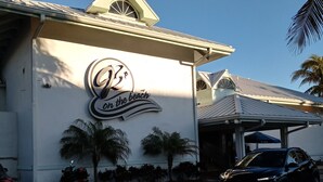 Un edificio con un cartel que dice "En la playa" y un coche estacionado frente a él.