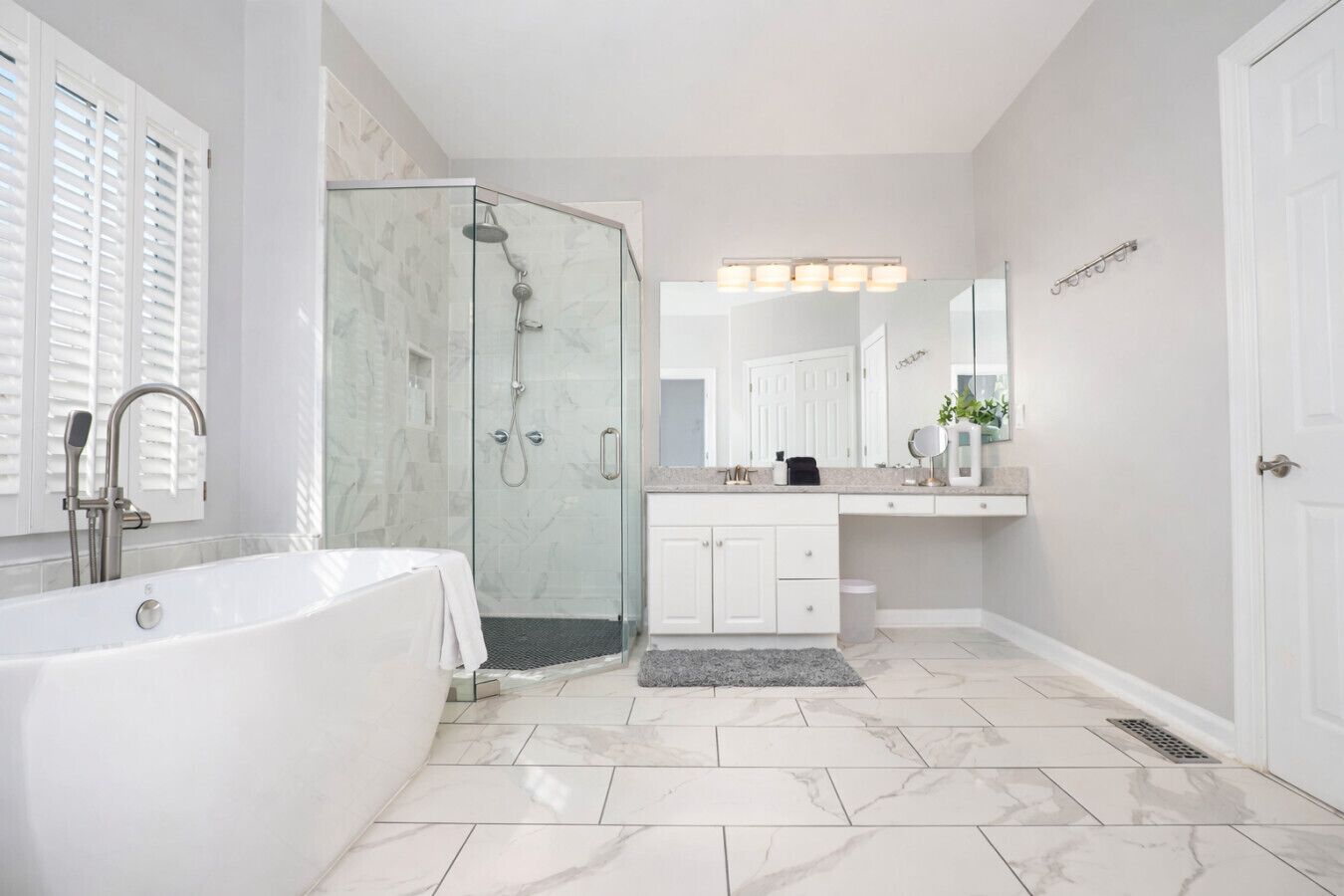 Un bagno moderno con doccia vetrata, una vasca freestanding e un mobile lavabo con specchio.