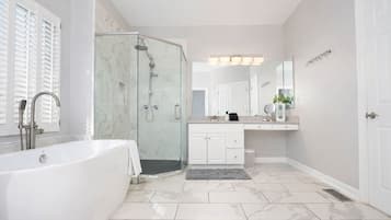Un bagno moderno con doccia vetrata, una vasca freestanding e un mobile lavabo con specchio.