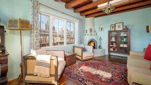 Una sala de estar acogedora con chimenea, vigas de madera y un tapete grande.