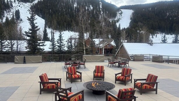 An outdoor seating area with chairs and a fire pit, surrounded by a snowy mountain landscape. - Slopeside Beautifully Renovated Kitchen & Bath 1.5 Baths Deck Outstanding Views (Keystone)