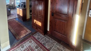 A hallway with a wooden door, a stone floor, and a rug. - Slopeside Beautifully Renovated Kitchen & Bath 1.5 Baths Deck Outstanding Views (Keystone)