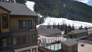 A hotel with a pool area, ski slope in the background, and mountainous terrain. - Slopeside Beautifully Renovated Kitchen & Bath 1.5 Baths Deck Outstanding Views (Keystone)