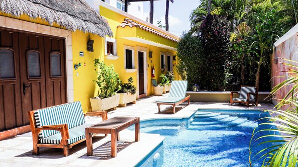 A pool area with lounge chairs and potted plants. - One Bedroom Suite, Serene, Pool, Gardens, Rooftop Terrace with Views (Isla Mujeres)